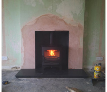 Charnwood C5 Woodburner - we raised the lintel, increased the width of the chamber; plastered, rendered and painted the chamber with heat proof paint in Charcoal; re-lined the chimney; fitted honed black granite hearths and connected the woodburner